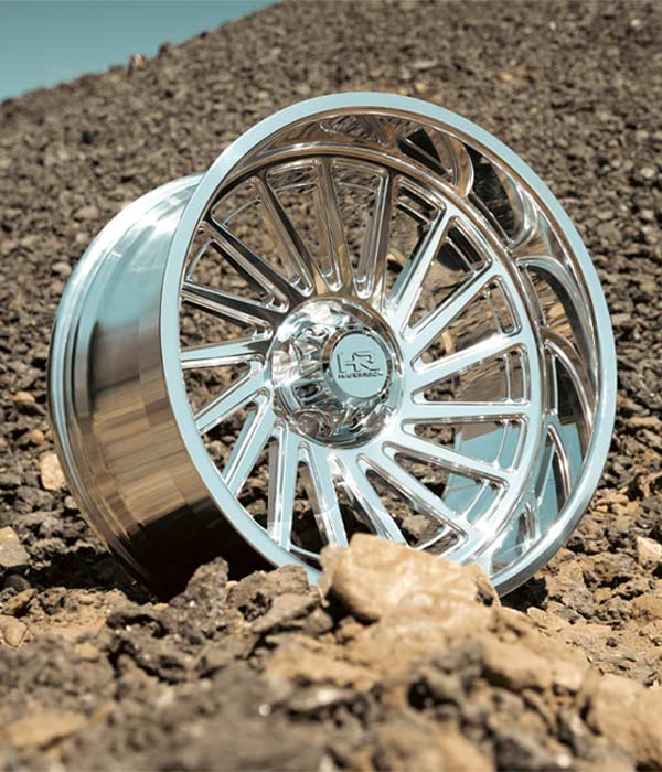 polished chrome h905 truck wheel on rocky hillside