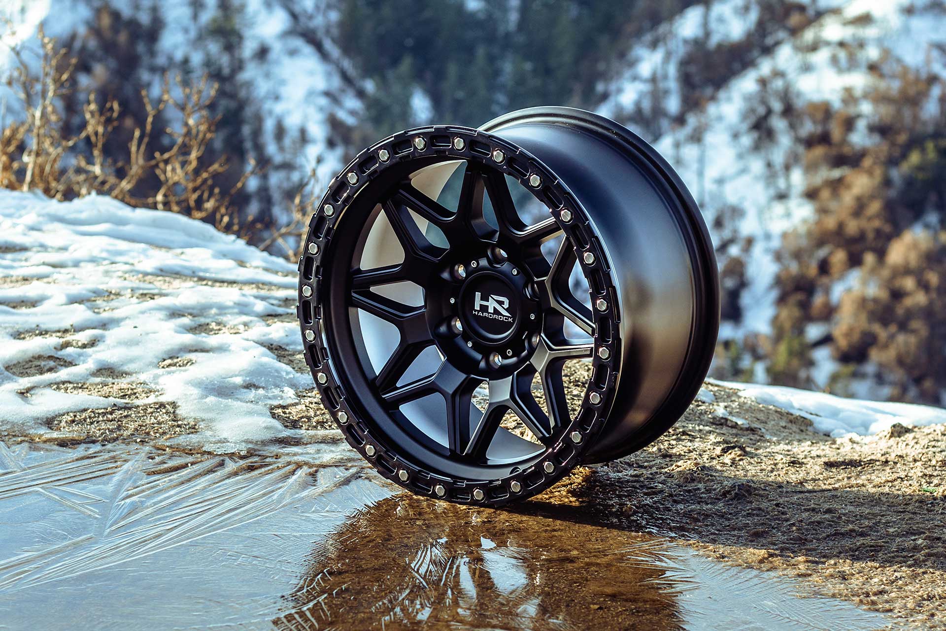 matte black hardrock offroad h105 on snowy dirt and ice with snowy mountain range