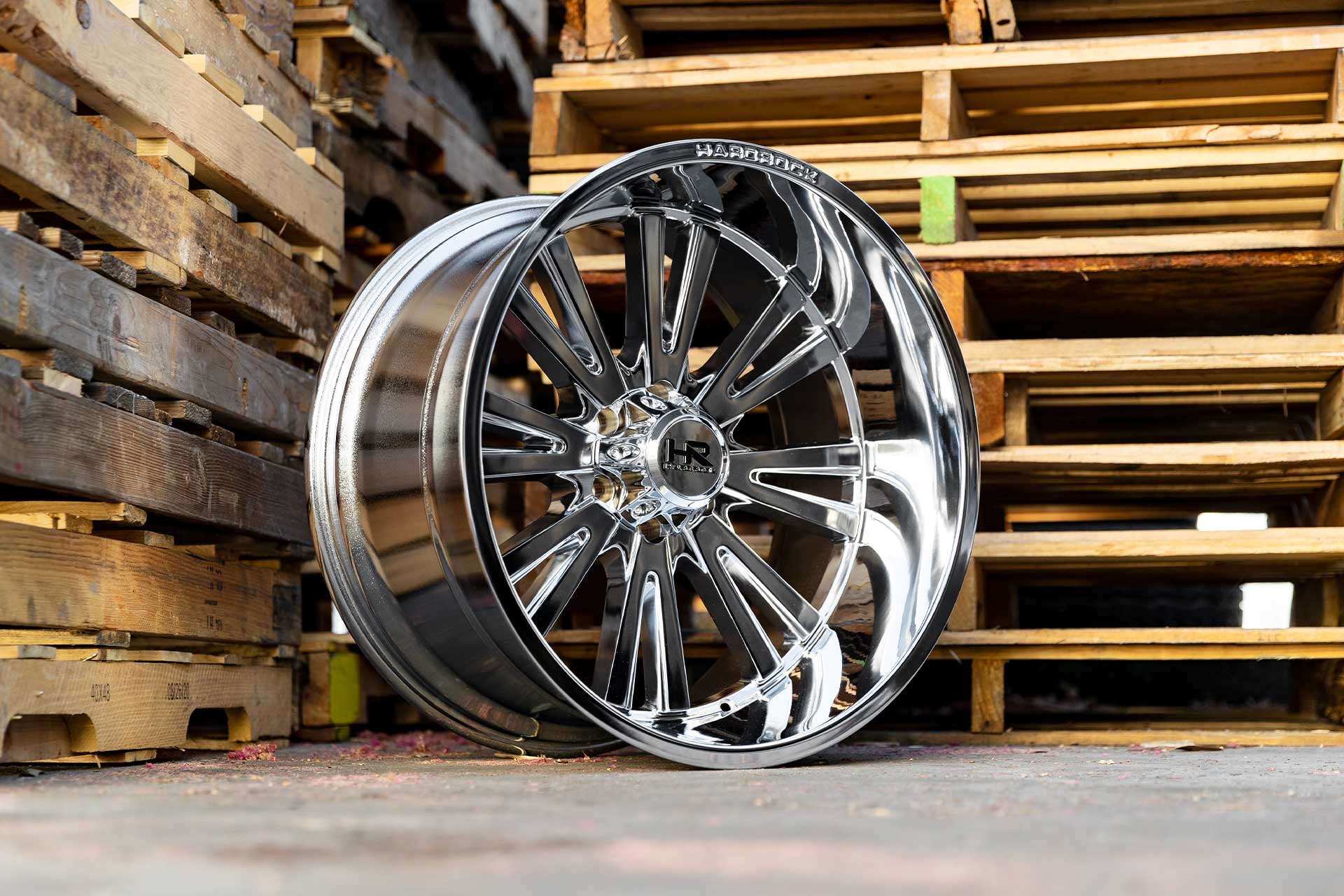 polished chrome hardrock offroad h503 on ground next to two wooden pallets