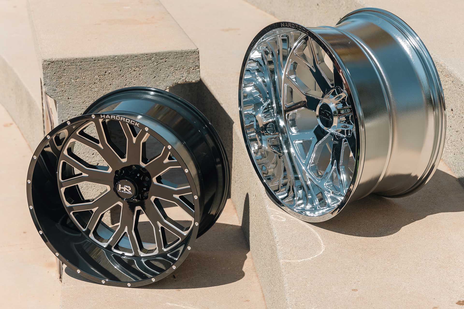 gloss black machined and polished chrome hardrock offroad h504s next to each other on concrete platforms