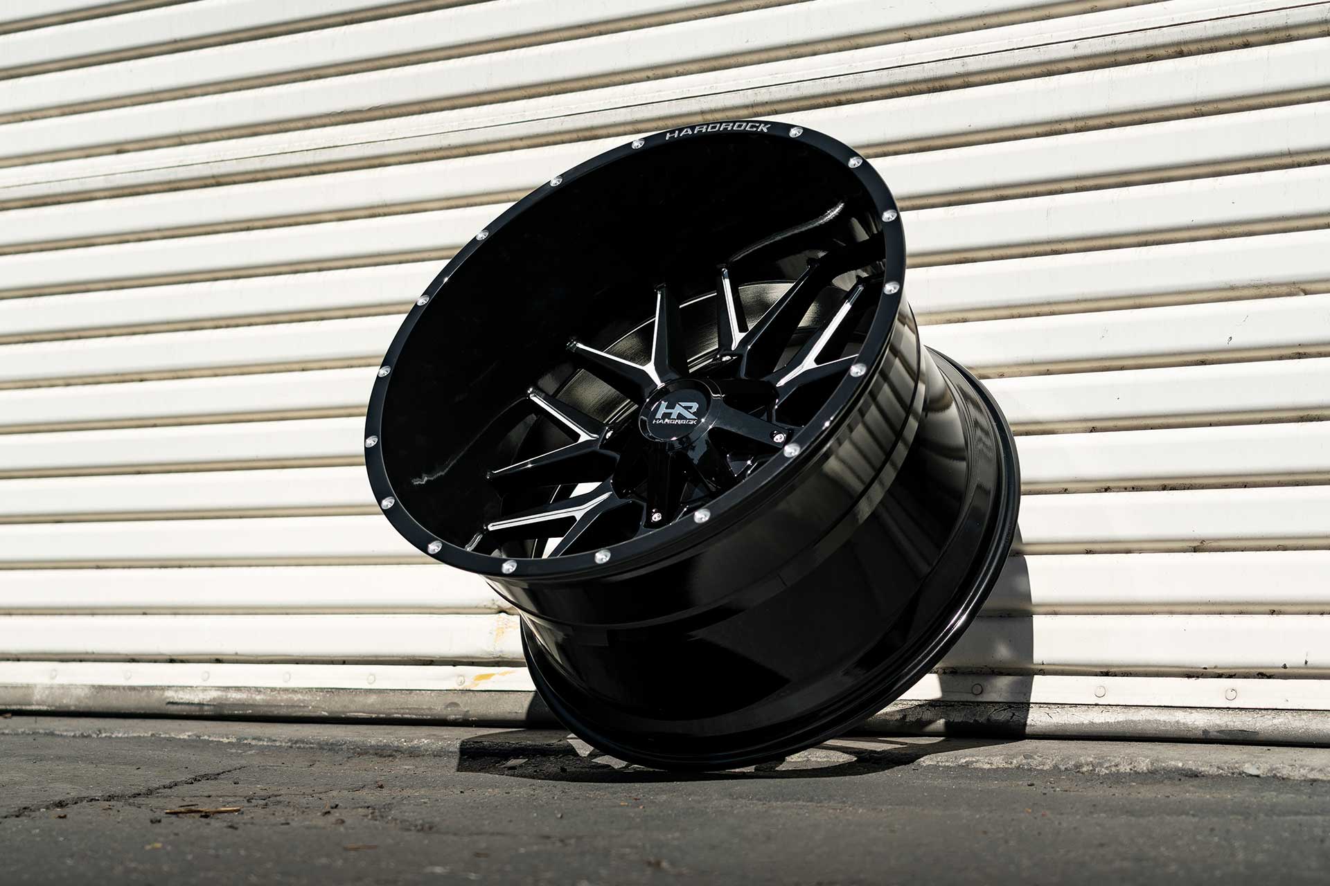 gloss black machined hardrock offroad h700 leaning against garage door