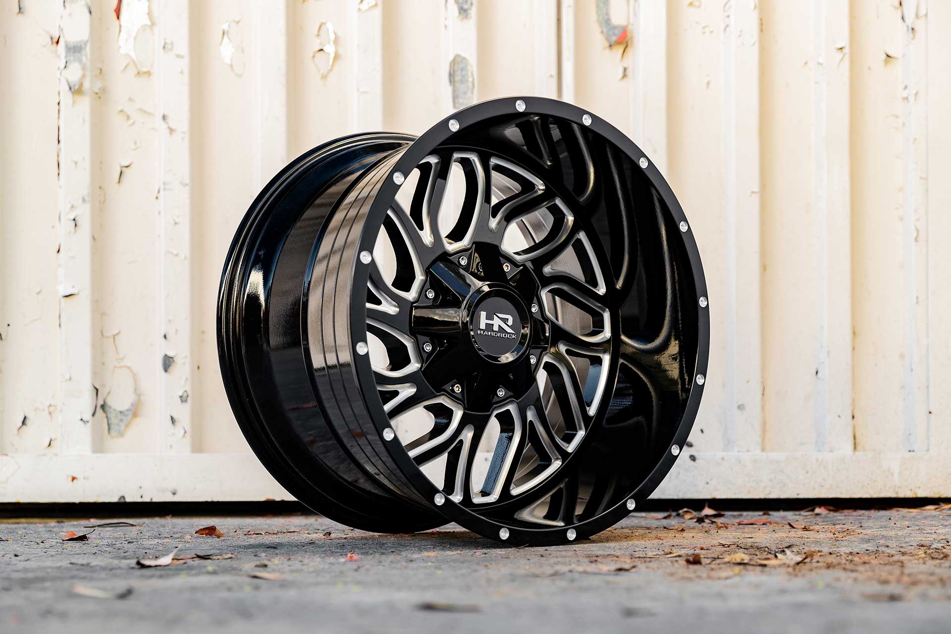 gloss black machined hardrock offroad h707 on ground with freight container behind it