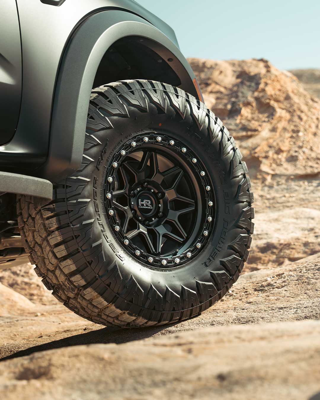 close up shot of matte black hardrock offroad h105 wheel in desert terrain