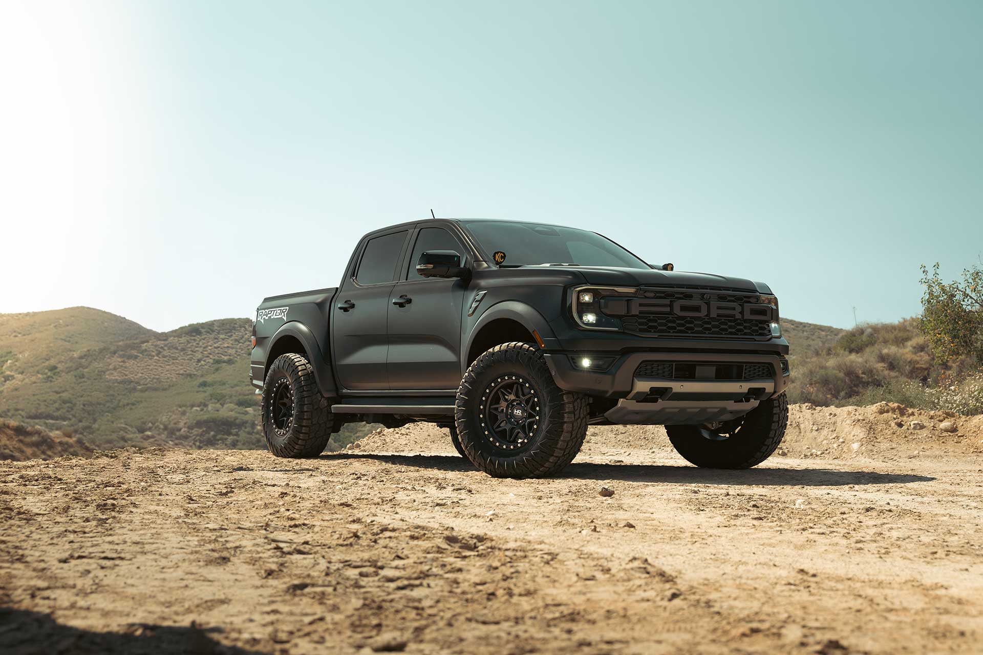matte black wrapped ford ranger raptor with matte black hardrock offroad h105 wheels on off road trail