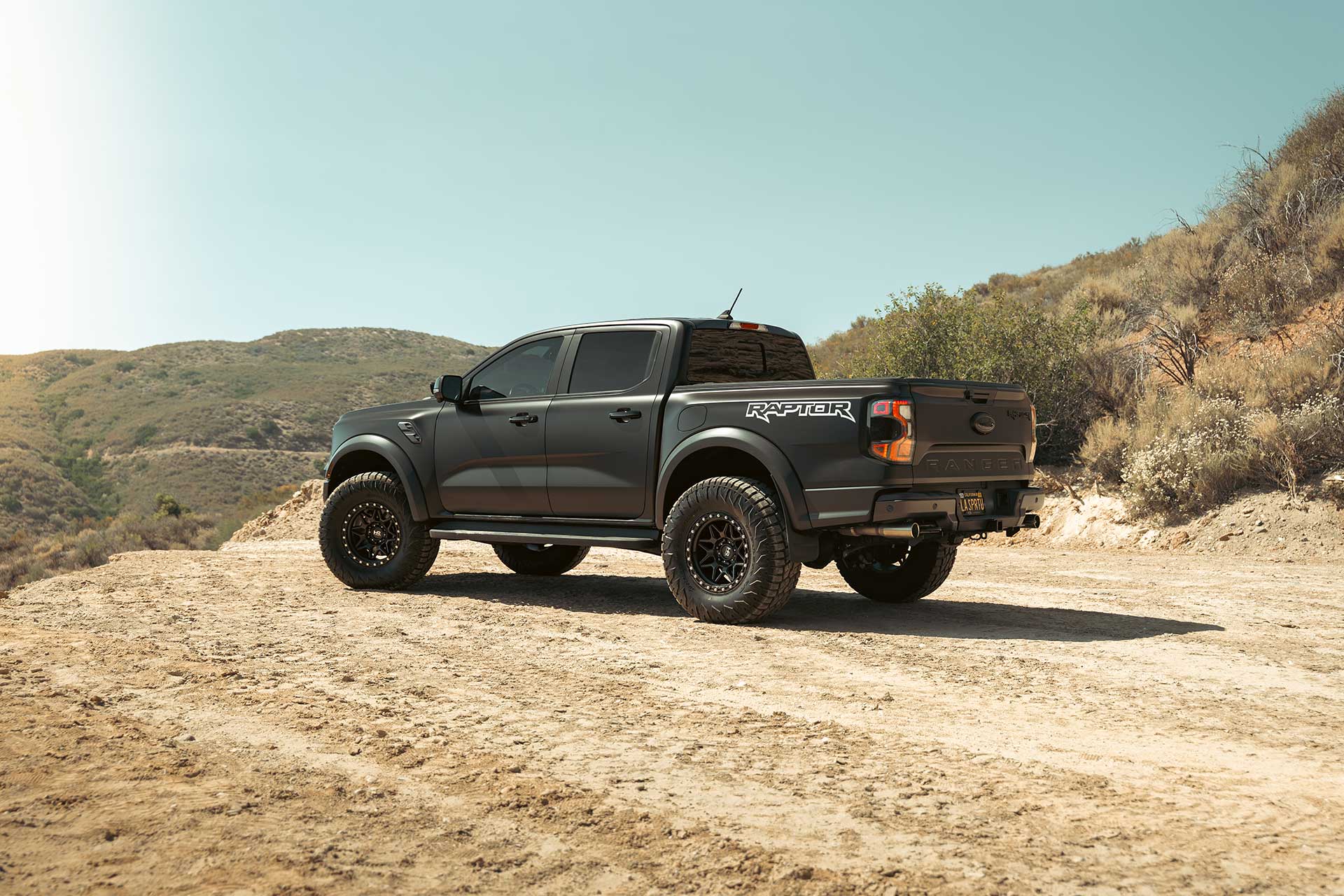 matte black wrapped ford ranger raptor with matte black hardrock offroad h105 wheels on off road trail