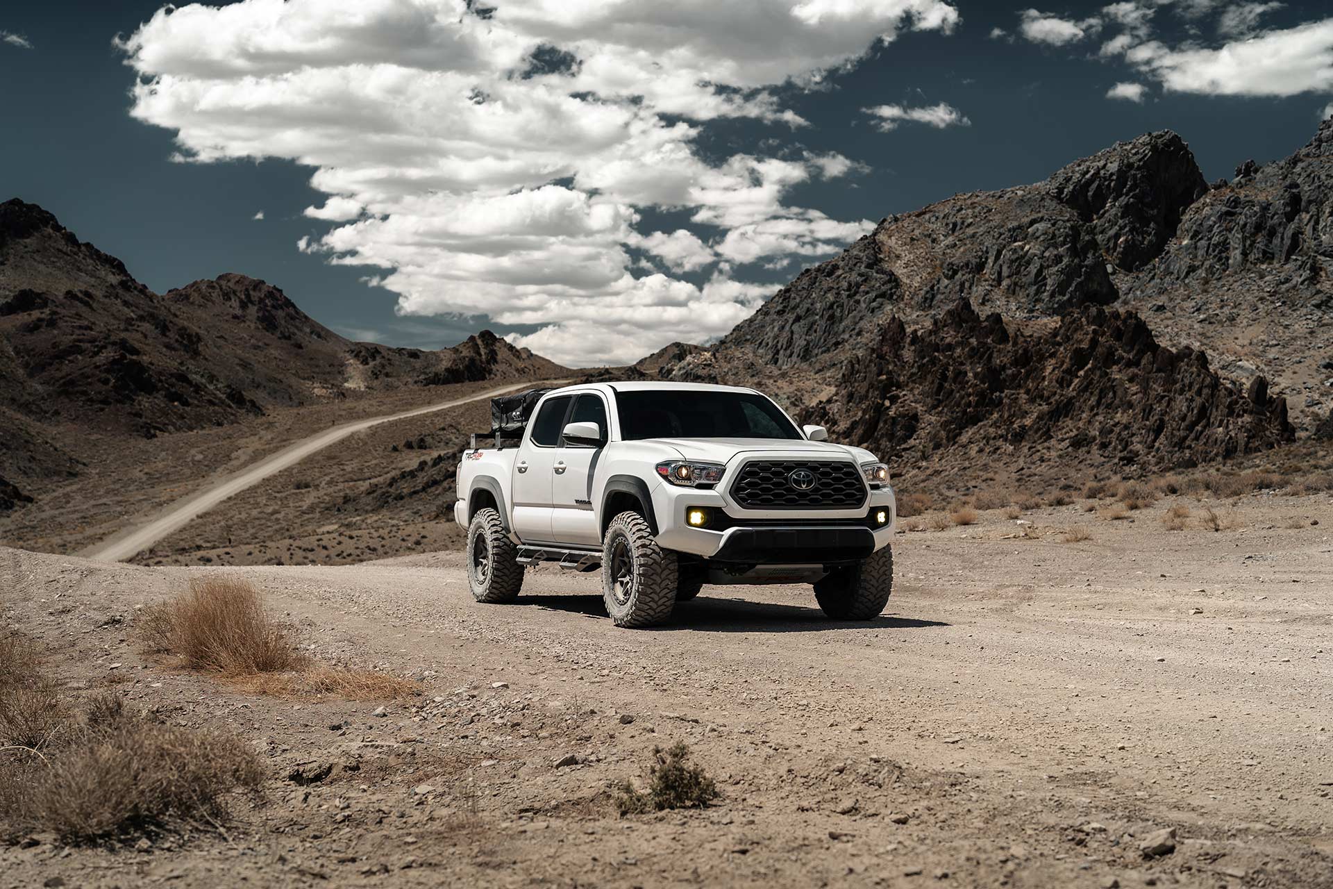 white overland toyota tacoma with matte bronze hardrock h105 off road wheels